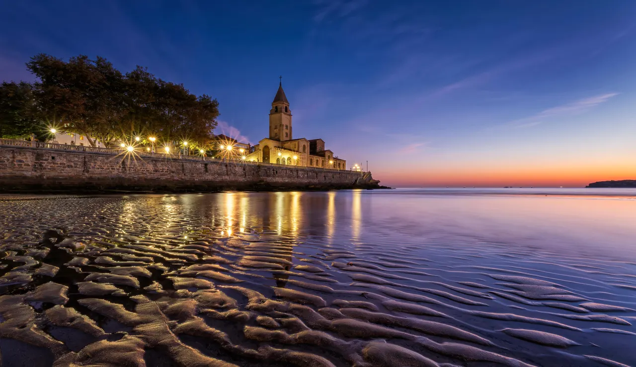 Con las primeras luces del amanecer, la playa de San Lorenzo de Gijón, reluce como el ORO