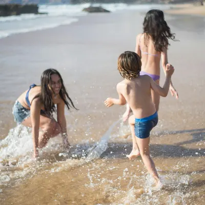 Niñas y niño jugando en la orilla de la playa