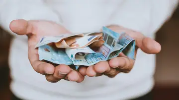 Foto de archivo de un hombre sosteniendo varios billetes de euro